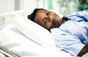sick black woman in hospital bed