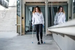 woman leaving hospital on crutches