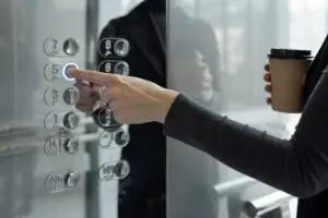 woman pushing elevator buttons