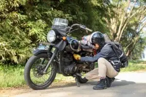 man maintaining motorcycle before riding