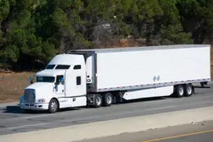 White 18-wheeler on the road. Trucks like these cause accidents in high numbers every year.