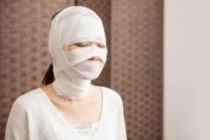 a woman wearing facial bandages