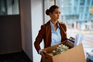 sad businesswoman taking her belongings out of the office