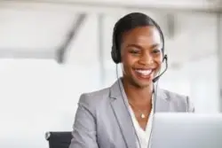 Smiling call center woman discussing the benefits of law firm case management integration with a potential law client.