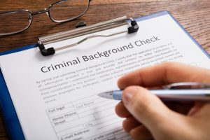 A person fills out a form to authorize a criminal background check.