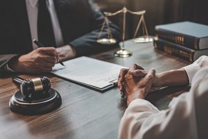 Lawyer meets with a client at his desk.