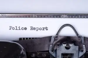 person typing a police report on a typewriter