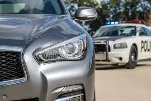 silver car with cop behind him