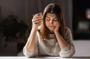 A thoughtful woman with a drink. Find out how DUIs can impact your mental health. 