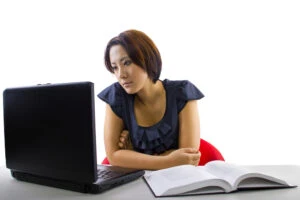 Woman looking at a computer and learning about foreign exchange programs and wondering if she can host a foreign exchange student with a DUI