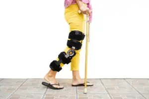 woman with a leg injury walking with a cane