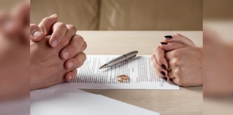 Husband and wife resting their hands on divorce paperwork