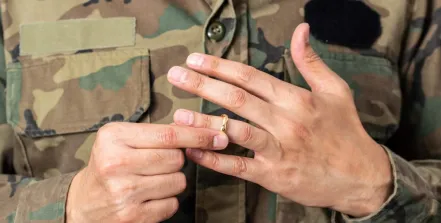 hands of military member taking off their ring