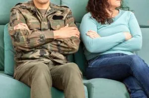 military member and spouse sitting on a couch facing different directions