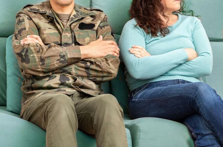 male miltary member and his wife sitting down facing opposite directions