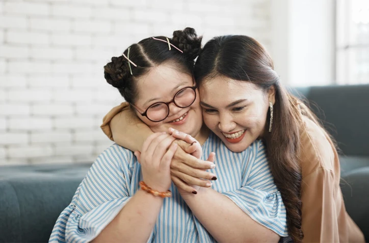 A mother hugging her daughter with special needs