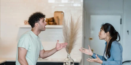 A couple argues at a dining room table