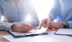 Closeup of the hands of a lawyer and conservator as they review paperwork regarding the powers of a conservator in Virginia.