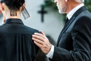 a man comforting a woman at a funeral