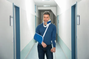 An injured man on crutches in a hallway.