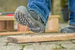 construction worker about to step on a nail