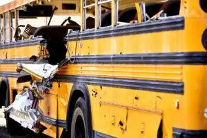 A school bus with heavy side damage after an accident.