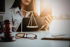 attorney reviews case notes with gavel and scales of justice on table