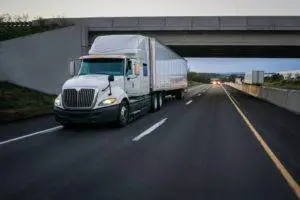white commercial truck driving down highway