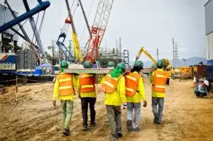 workers carrying materials across construction site