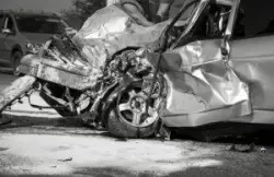 A car with severe front-end damage after a collision.