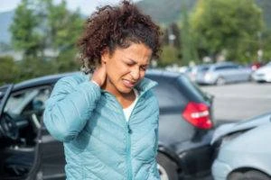 a woman grabbing her neck after a car accident