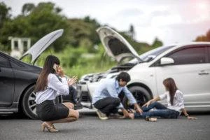 driver tends to passenger while motorist calls for help after wreck