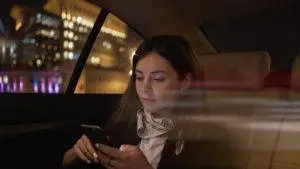 female rideshare passenger looking at phone