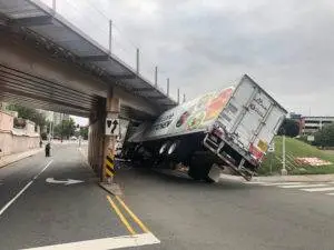 A truck stuck under an underpass.