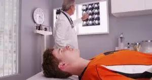 doctor examining brain scans of injured athlete