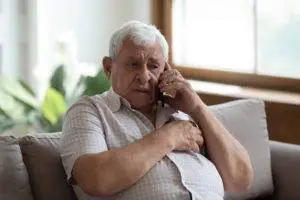 elderly man speaking with lawyer on phone