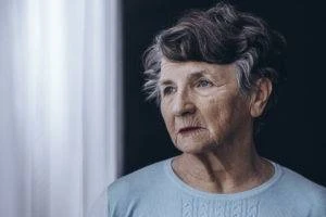 elderly woman staring out window