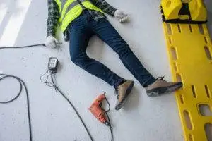 electrocuted construction worker on ground next to gurney