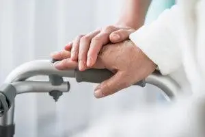 nurse helping elderly person with walker