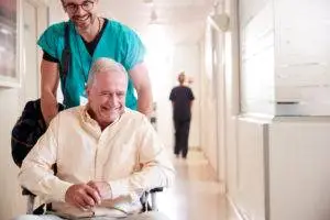 orderly helps senior patient leave hospital