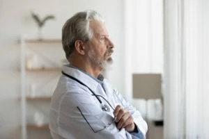 serious doctor looks out window