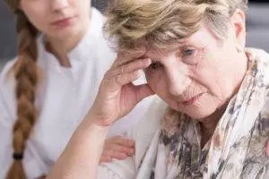 worried elder touched by nurse