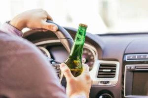 man driving with beer in hand