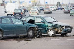 two damaged cars in road after crash