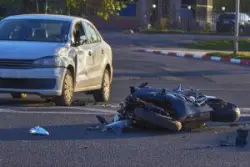 a damaged motorcycle and car after a collision