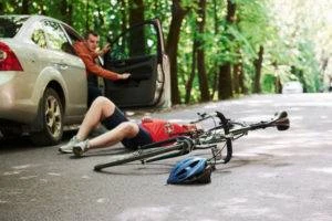 cyclist on ground after being hit by car