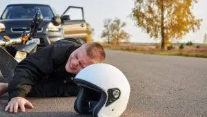 motorcyclist wincing in pain after accident