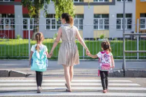 mother walks daughters through crosswalk