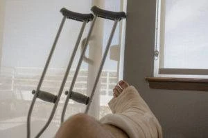 truck-accident-victim-with-their-leg-in-a-cast-and-crutches-in-the-background