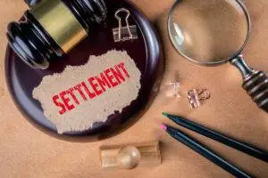 settlement-clipping-sits-on-gavel-with-magnifying-glass